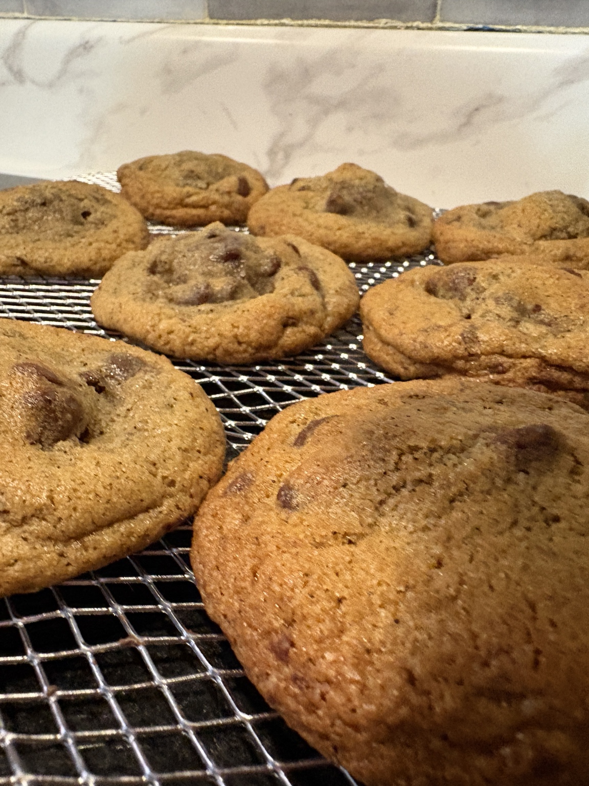 Brulett Nutella-filled chocolate chip cookies on a cooling rack