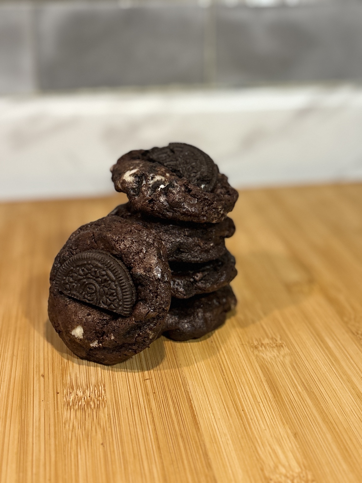 A stack of small Brulett chocolate cookies topped with half an Oreo