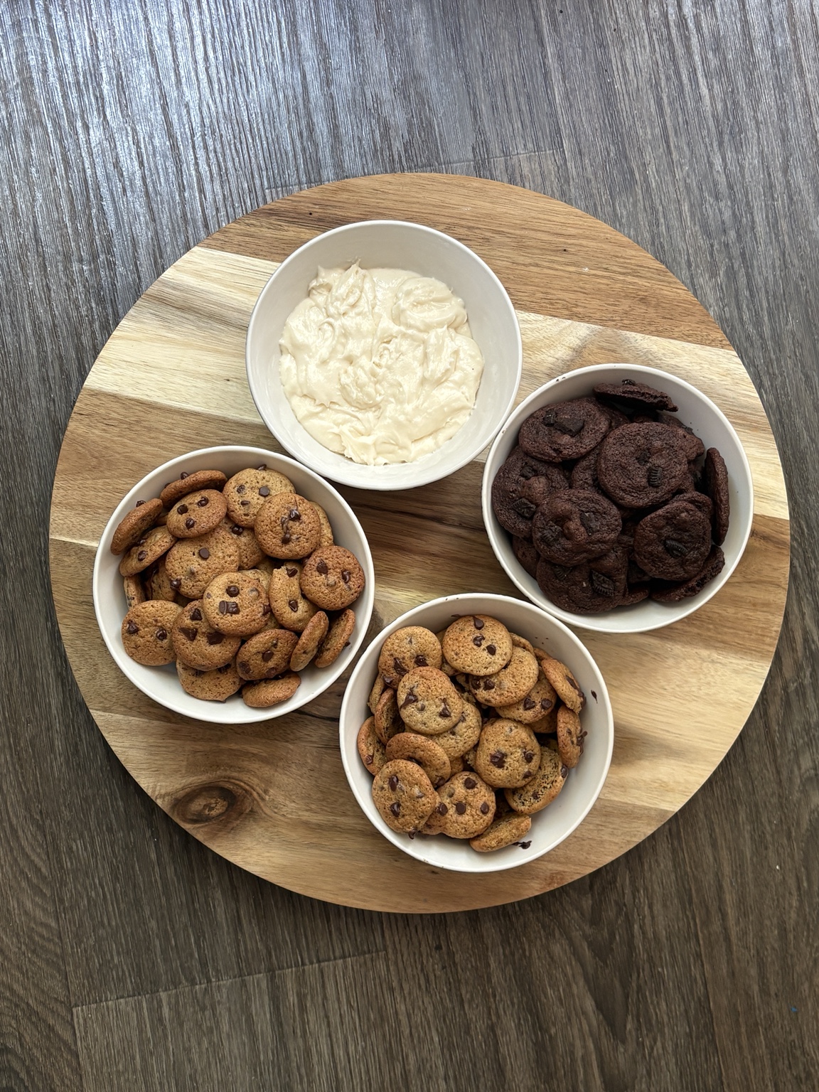 Party serving idea: two bowls of mini chocolate chip cookies, one bowl of mini chocolate cookies, and a bowl of dip